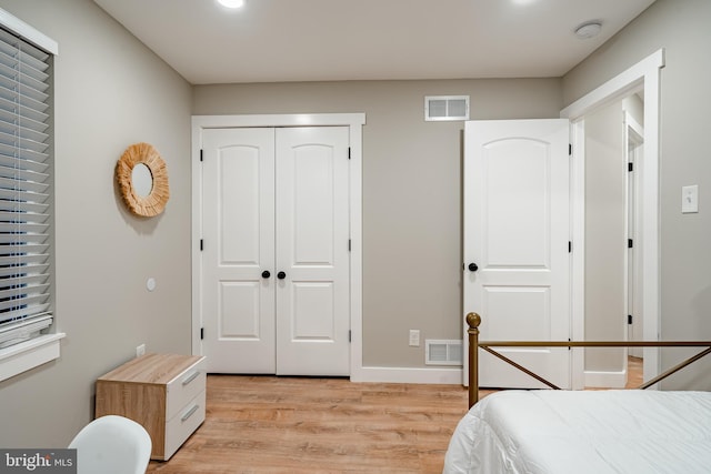 bedroom featuring visible vents, a closet, and light wood-style flooring