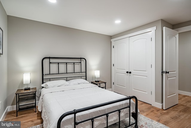 bedroom featuring recessed lighting, a closet, baseboards, and light wood-type flooring