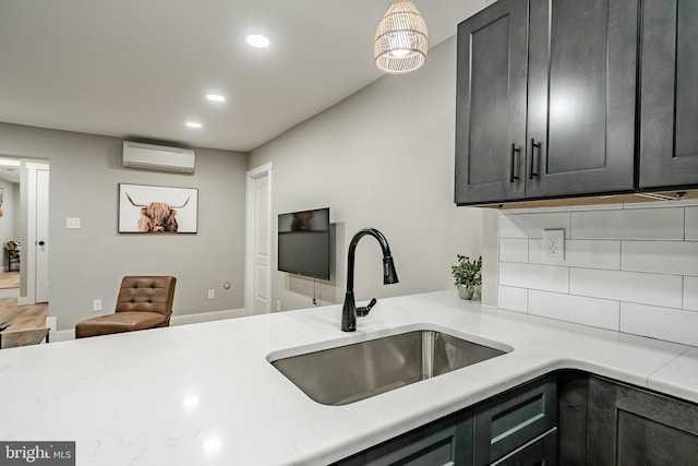 kitchen with recessed lighting, a sink, light stone counters, and a wall mounted AC
