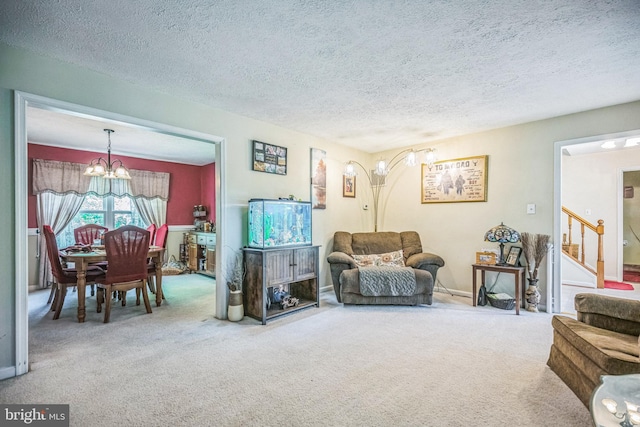 carpeted living room with an inviting chandelier, stairs, and a textured ceiling