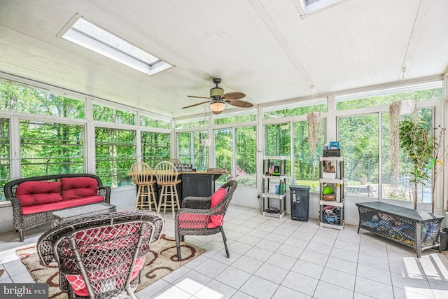 sunroom / solarium featuring a skylight, ceiling fan, and an outdoor hangout area