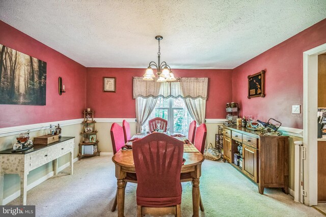 carpeted dining room featuring an inviting chandelier and a textured ceiling