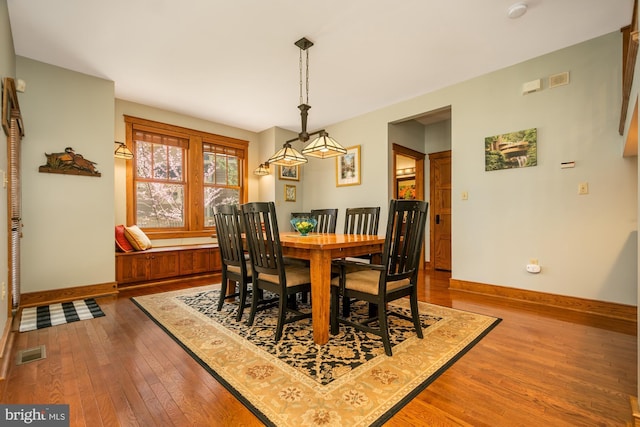 dining area featuring visible vents, baseboards, and hardwood / wood-style flooring