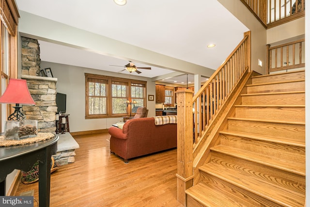 living area with a ceiling fan, baseboards, recessed lighting, wood finished floors, and stairway