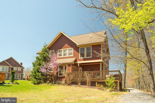 rear view of house with a lawn and a deck