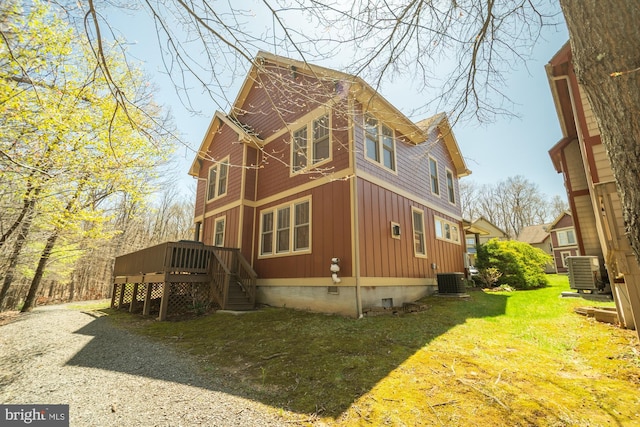 view of side of property with board and batten siding, central AC, crawl space, and a deck