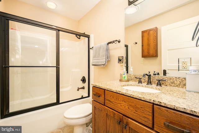 bathroom with vanity, combined bath / shower with glass door, tile patterned floors, and toilet