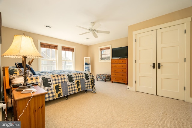 carpeted bedroom featuring a closet, a ceiling fan, and visible vents