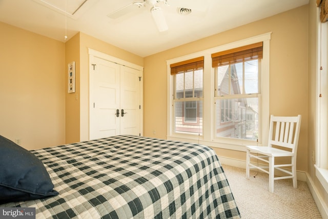 bedroom featuring a closet, carpet floors, a ceiling fan, and attic access