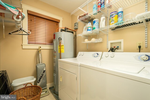 clothes washing area featuring water heater, laundry area, and washer and clothes dryer