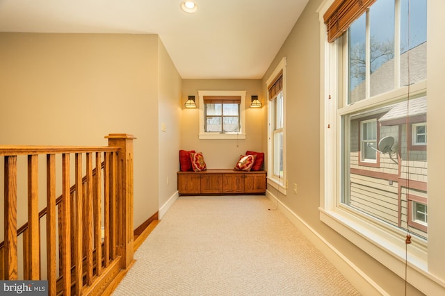 hallway with carpet floors, recessed lighting, baseboards, and an upstairs landing