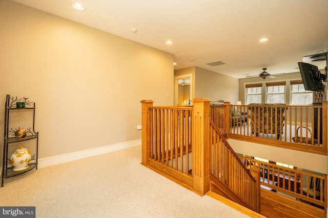 hallway featuring carpet flooring, recessed lighting, baseboards, and an upstairs landing