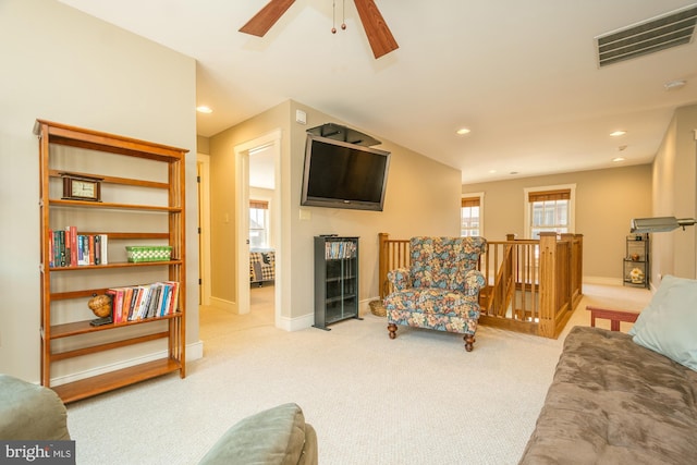 carpeted living room featuring baseboards, ceiling fan, and visible vents