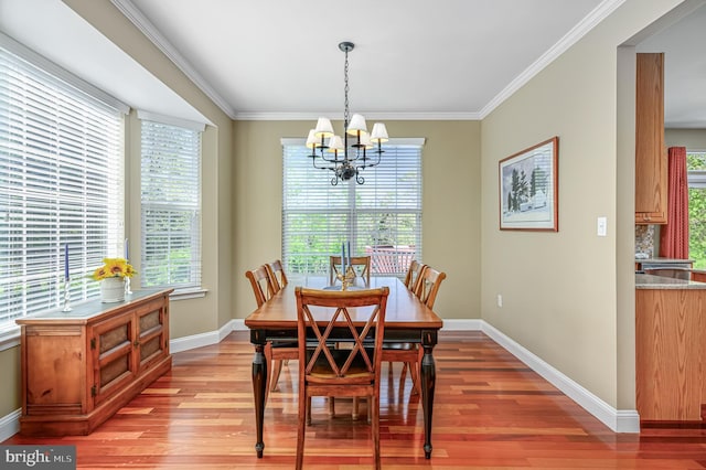dining space featuring crown molding, a healthy amount of sunlight, a chandelier, and light wood-type flooring