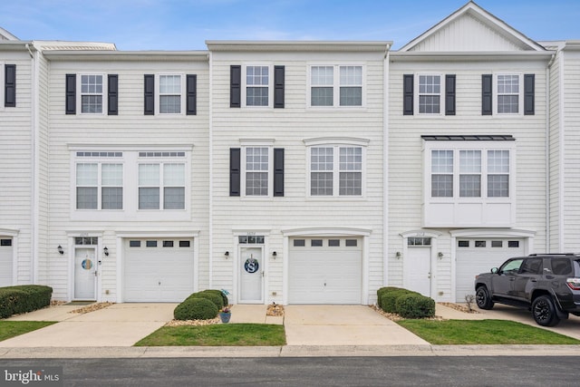 multi unit property with concrete driveway and an attached garage