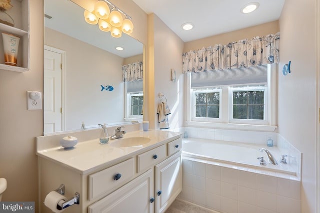 bathroom featuring a garden tub and vanity
