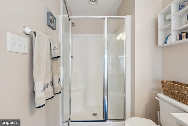 bathroom with a shower stall and toilet