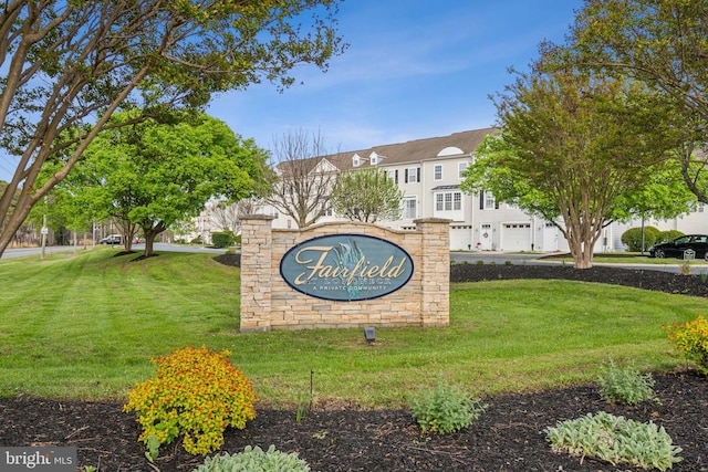 community sign featuring a lawn and a garage