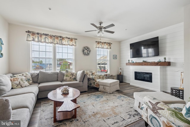living room with a glass covered fireplace, ceiling fan, and wood finished floors