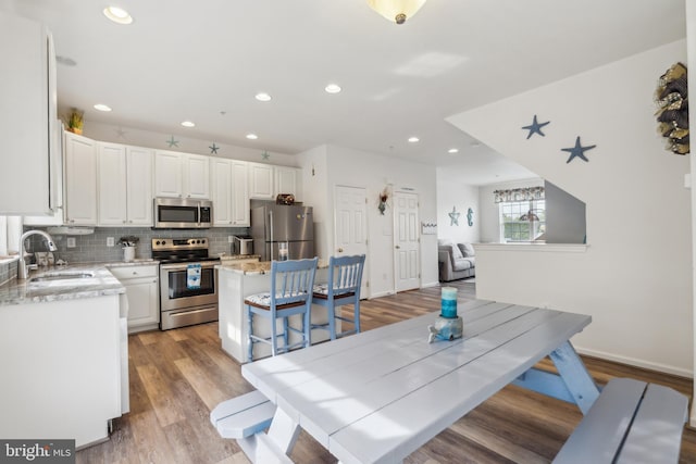 dining space with recessed lighting, baseboards, and light wood finished floors