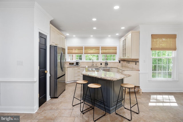 kitchen with a breakfast bar area, appliances with stainless steel finishes, a wealth of natural light, and a sink