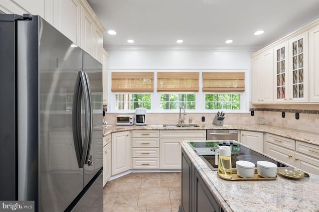 kitchen featuring a sink, appliances with stainless steel finishes, backsplash, and ornamental molding