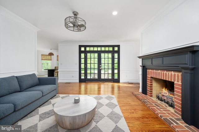 living room with ornamental molding, light wood finished floors, and a decorative wall