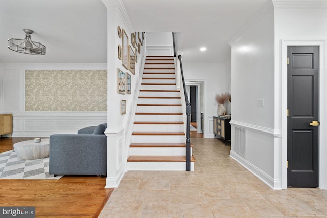stairs featuring crown molding, recessed lighting, wainscoting, and wallpapered walls