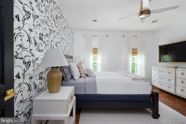 bedroom featuring a ceiling fan, dark wood-style floors, and visible vents