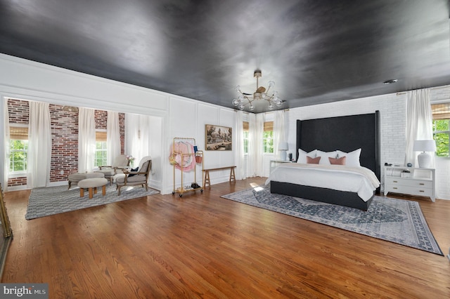 bedroom featuring wood finished floors and a notable chandelier
