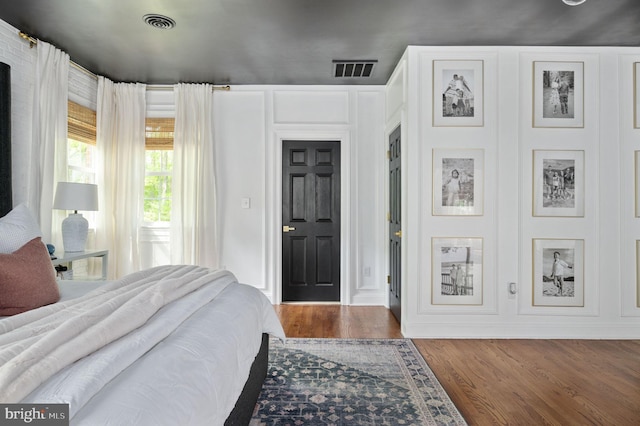 bedroom featuring visible vents and wood finished floors