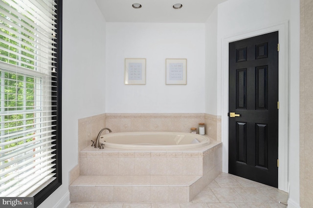 full bathroom with a garden tub and tile patterned flooring