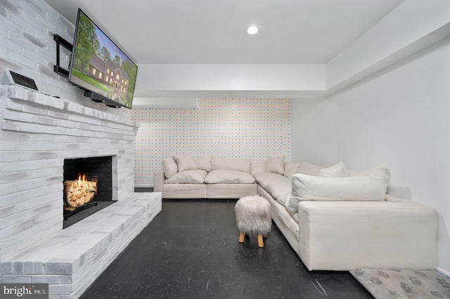 living room with recessed lighting, a brick fireplace, an accent wall, and wallpapered walls