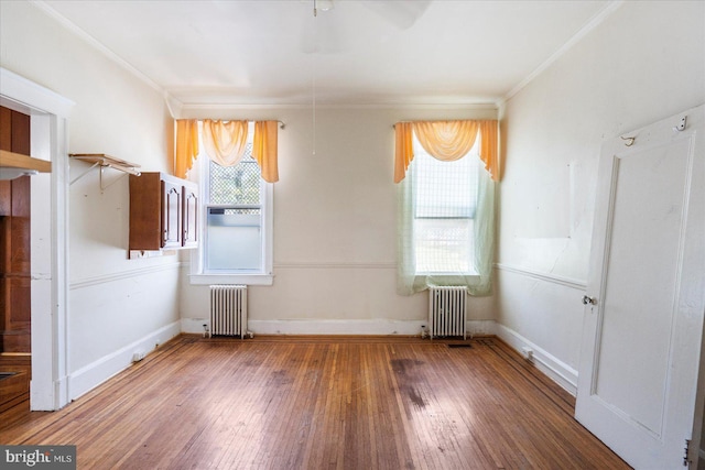 unfurnished bedroom with baseboards, ornamental molding, radiator, and hardwood / wood-style floors