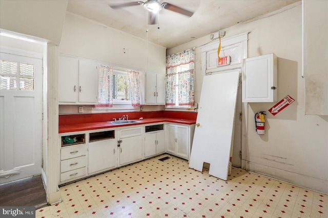 2611 Elsinore Ave, Baltimore, MD 21216 - kitchen featuring a sink, white cabinets, a ceiling fan, and a healthy amount of sunlight