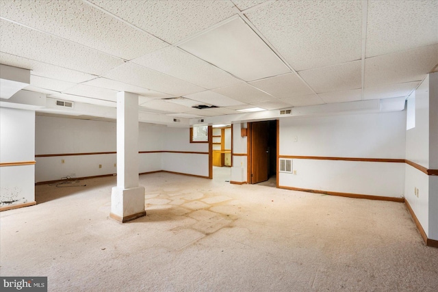 finished basement with baseboards, carpet floors, a paneled ceiling, and visible vents
