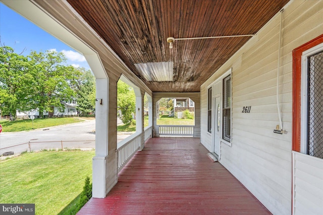 wooden deck with a porch and a lawn