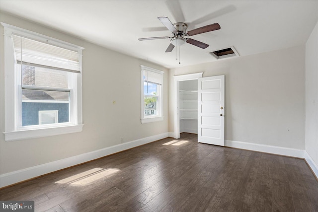 unfurnished bedroom featuring a ceiling fan, baseboards, dark wood finished floors, and a closet