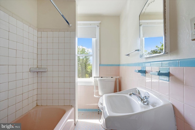 bathroom featuring  shower combination, wainscoting, toilet, and tile walls