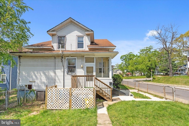 view of front of property featuring a fenced backyard, a shingled roof, and a front lawn