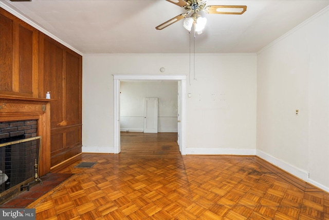 unfurnished living room featuring crown molding, baseboards, ceiling fan, and a brick fireplace