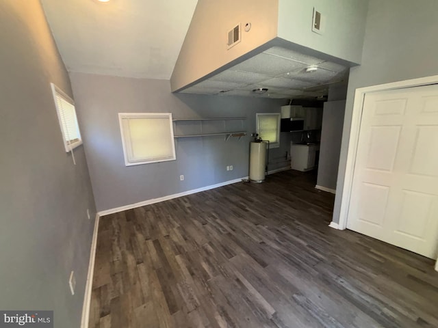 unfurnished living room featuring baseboards, gas water heater, dark wood finished floors, and visible vents