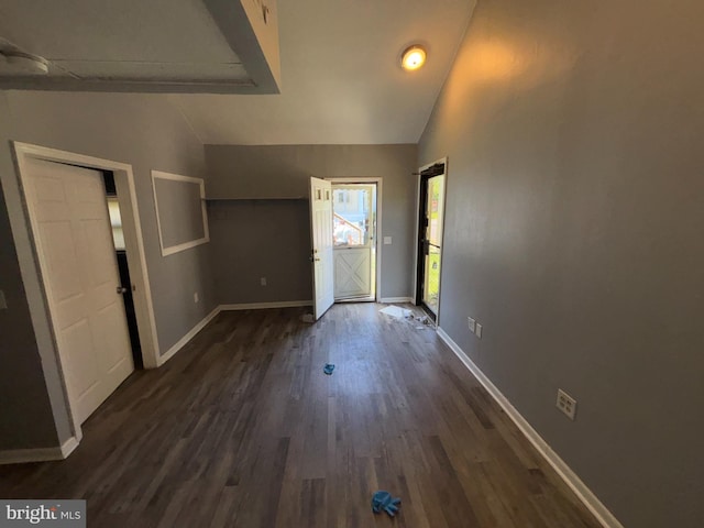 foyer entrance featuring baseboards, dark wood-style floors, and high vaulted ceiling