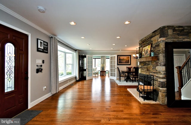 entrance foyer featuring ornamental molding, wood-type flooring, and baseboards