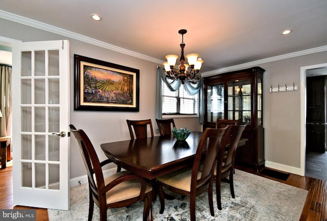 dining area featuring baseboards, an inviting chandelier, recessed lighting, ornamental molding, and wood finished floors
