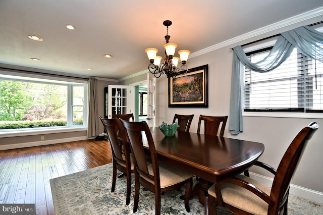 dining space featuring baseboards, a notable chandelier, a wealth of natural light, and ornamental molding
