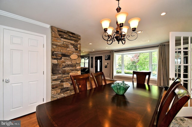 dining room with an inviting chandelier, wood finished floors, recessed lighting, and ornamental molding