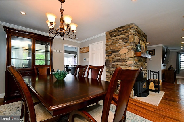 dining area featuring hardwood / wood-style floors, an inviting chandelier, crown molding, and plenty of natural light