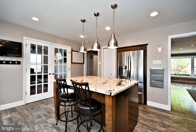kitchen featuring a center island, stainless steel fridge with ice dispenser, baseboards, french doors, and dark wood finished floors