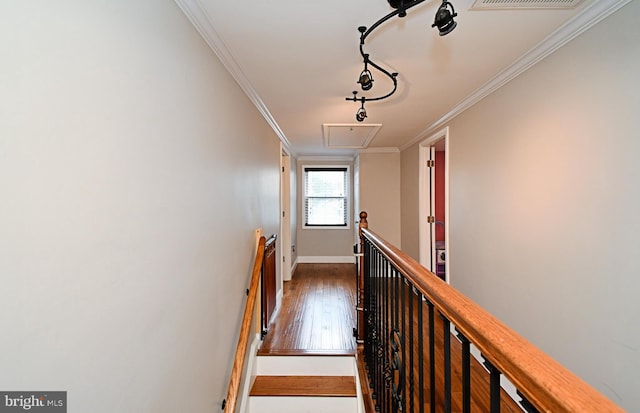 corridor with hardwood / wood-style floors, attic access, an upstairs landing, and crown molding